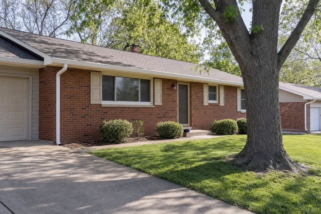 Red-brick ranch with a long white seamless gutter along the eave and a new corner downspout